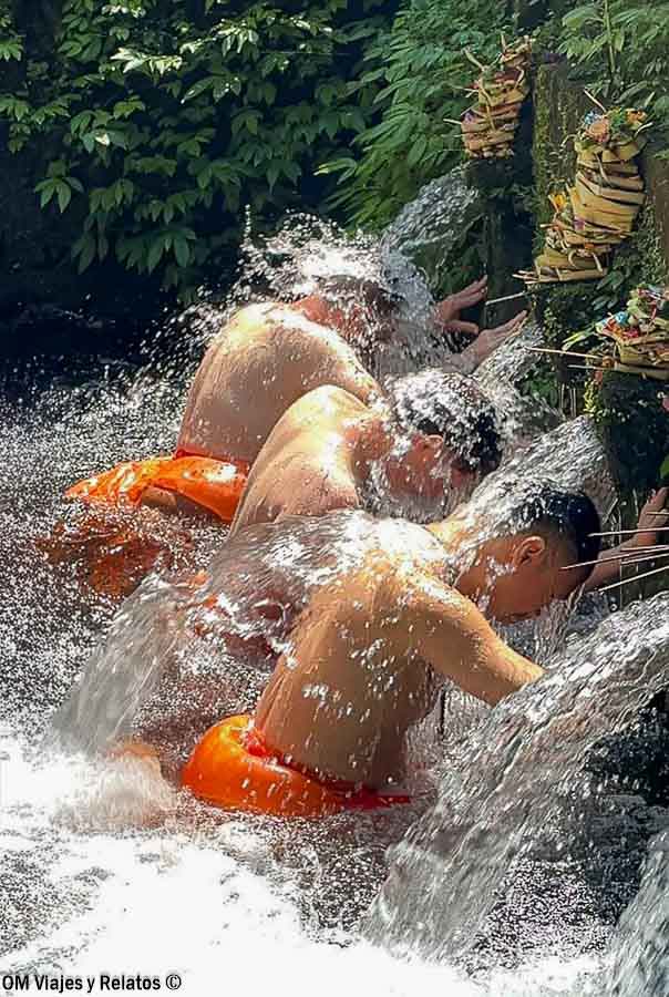 Foto de JC y Raúl realizando un baño de purificación en el templo Pura Mengening de Bali