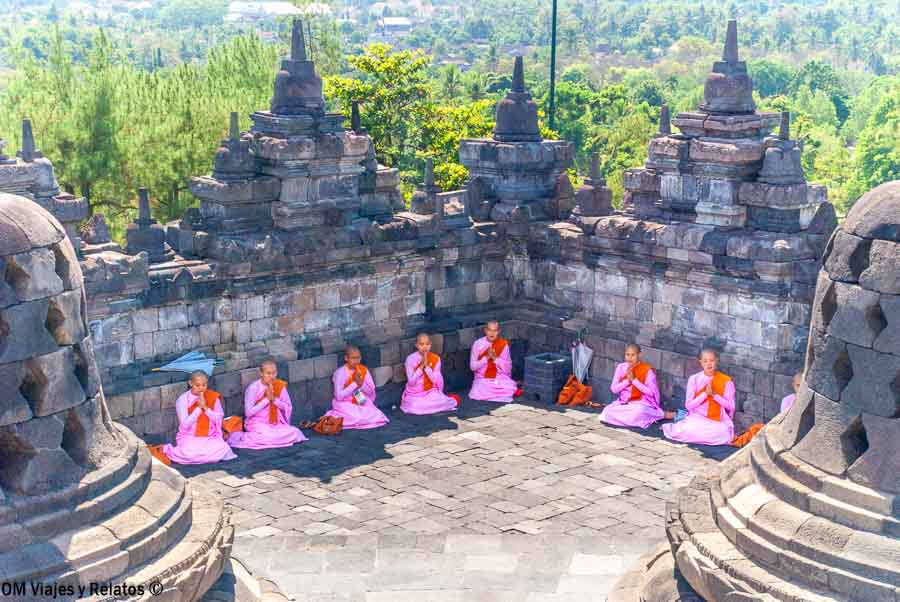 Monjas budistas meditando entre las estupas de Borobudur
