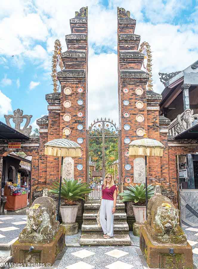 Foto mía junto a una puerta tradicional balinesa decorada con ofrendas en Bali