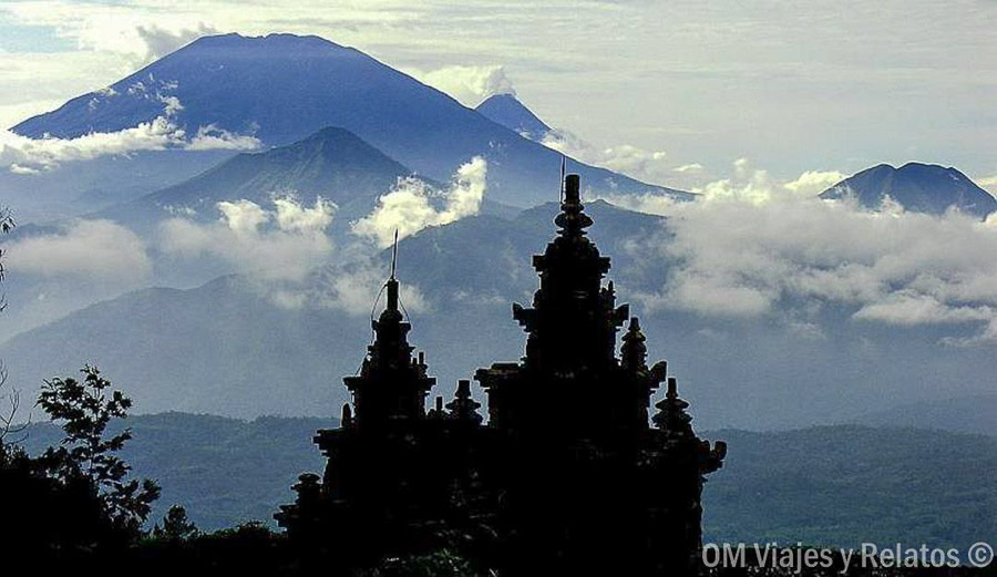 Silueta de un templo de Java con volcanes entre las nubes durante nuestra ruta por Java