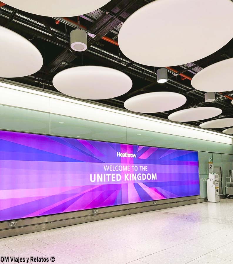 Llegada al aeropuerto de Heathrow con cartel de bienvenida al Reino Unido