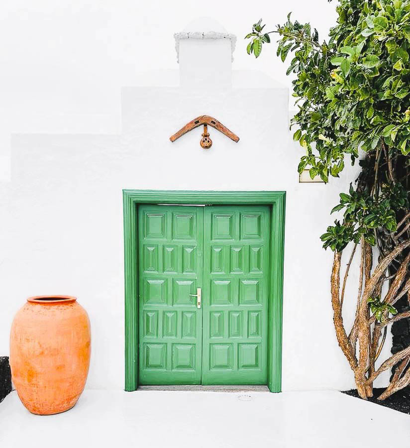 Fachada blanca con puerta verde de arquitectura tradicional en Lanzarote