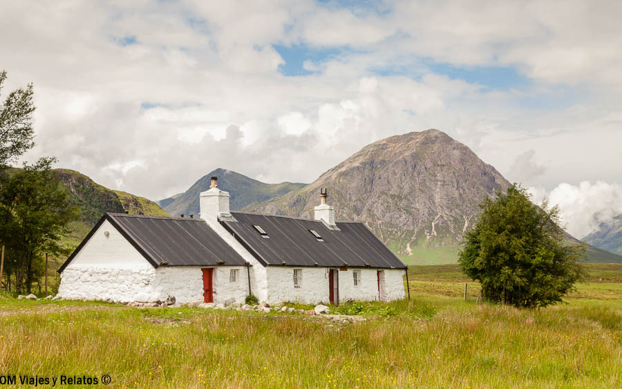 Casa tradicional blanca entre montañas durante una ruta por Glencoe en Escocia