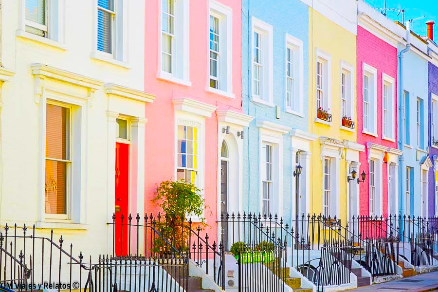 Fachadas de casas de colores pastel en Londres, con puertas de entrada y pequeñas verjas negras