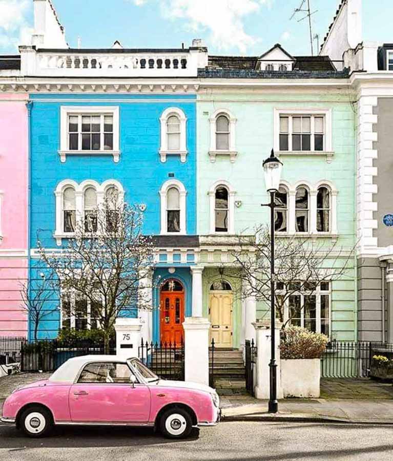Casas de colores en Notting Hill con coche rosa aparcado en Londres