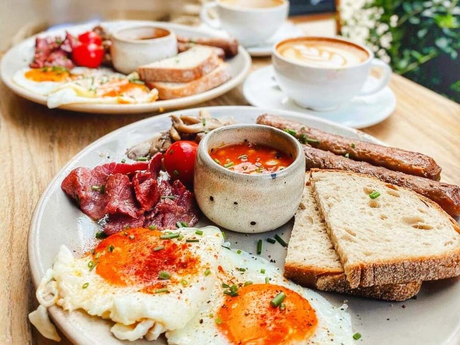 Desayuno inglés con huevos, salchichas, bacon, pan y café en Londres