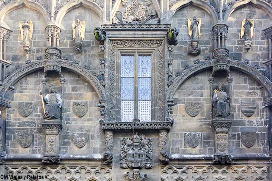Detalle de la fachada gótica de la Torre de la Pólvora de Praga con esculturas y escudos
