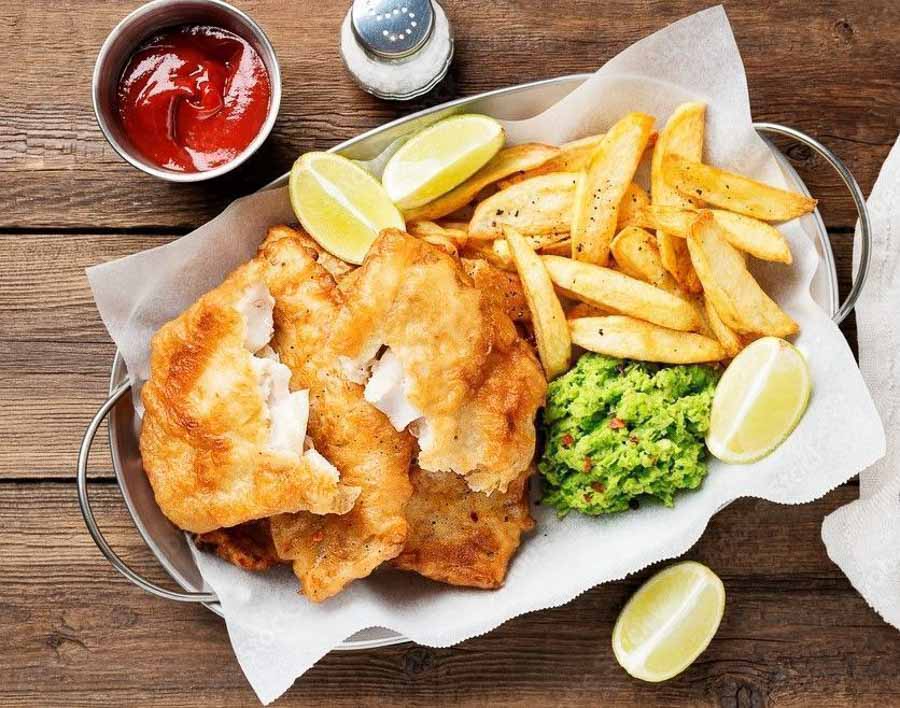 Fish and chips tradicional con patatas fritas y guisantes en Londres