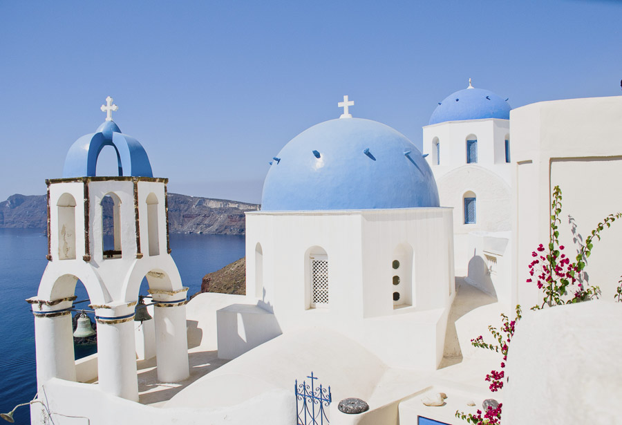 Iglesia de cúpulas azules en Santorini con vistas a la caldera y al mar Egeo