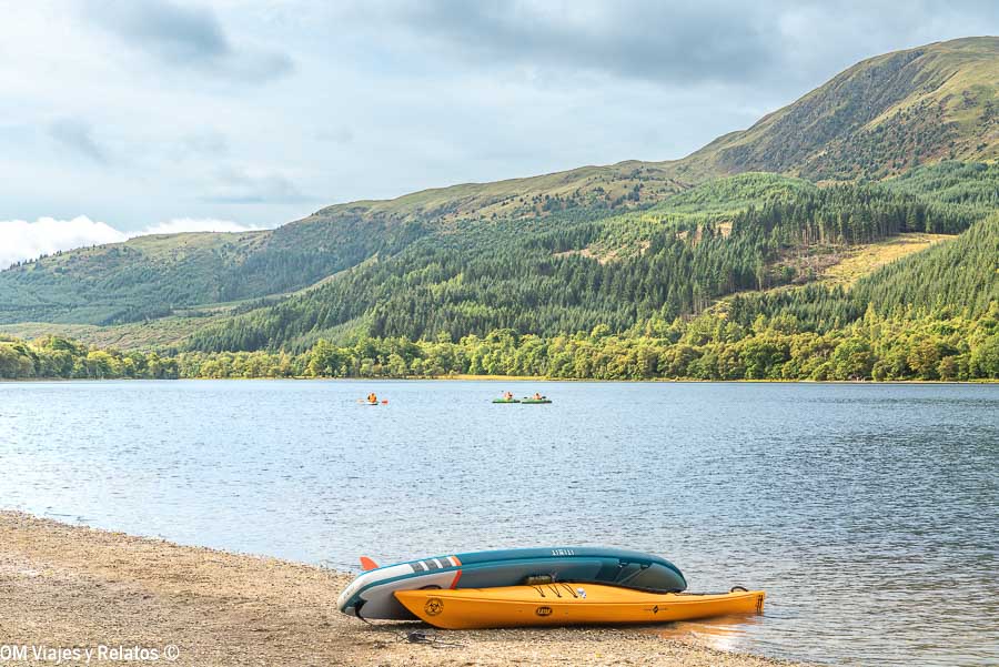 Kayaks junto a un lago rodeado de montañas durante una ruta por Escocia