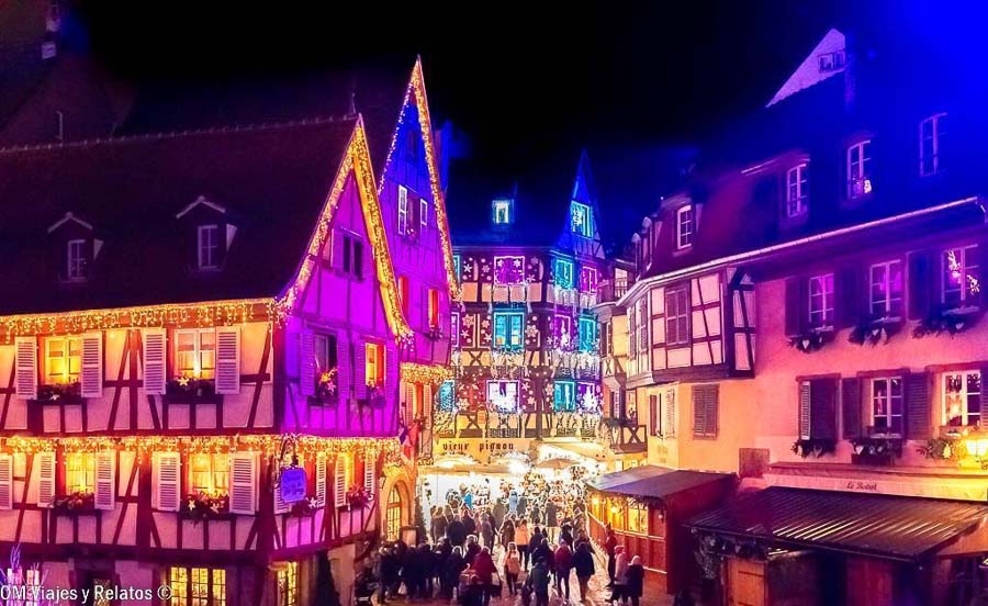 Mercados de Navidad de Alsacia iluminados por la noche entre casas tradicionales de Colmar