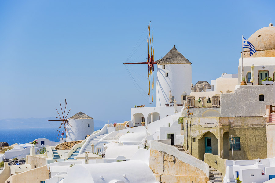 Molinos de viento y casas blancas de Oia en Santorini con vistas al mar Egeo