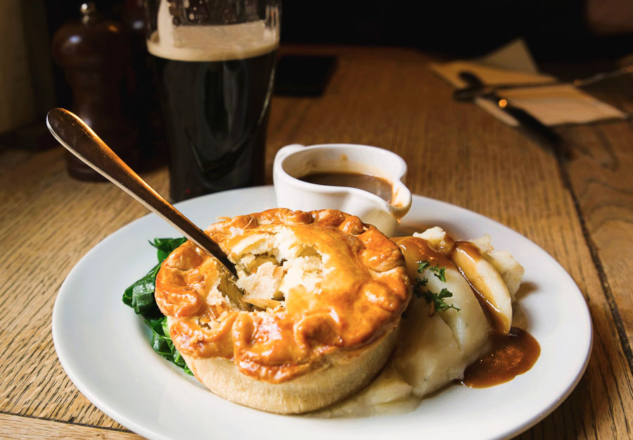 Pastel de carne británico con puré de patatas y salsa gravy en Londres