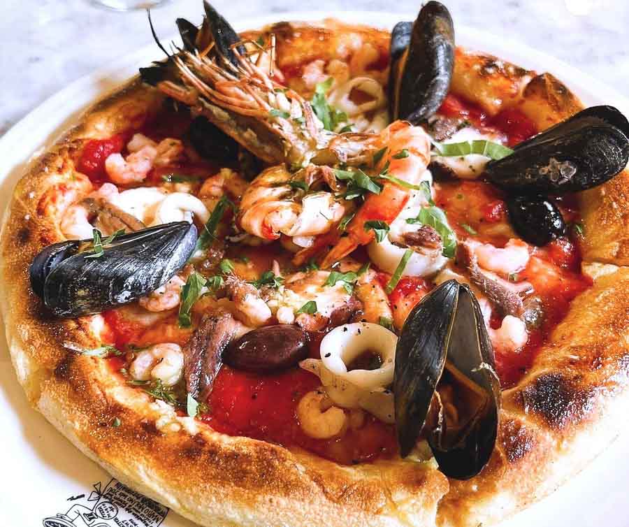Pizza de marisco con mejillones, gambas y calamares durante una comida en Londres