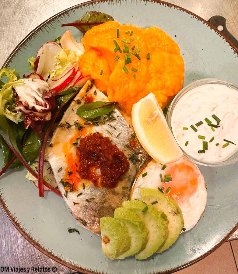 Plato de pescado con puré, huevo, aguacate y ensalada servido en un restaurante de Praga