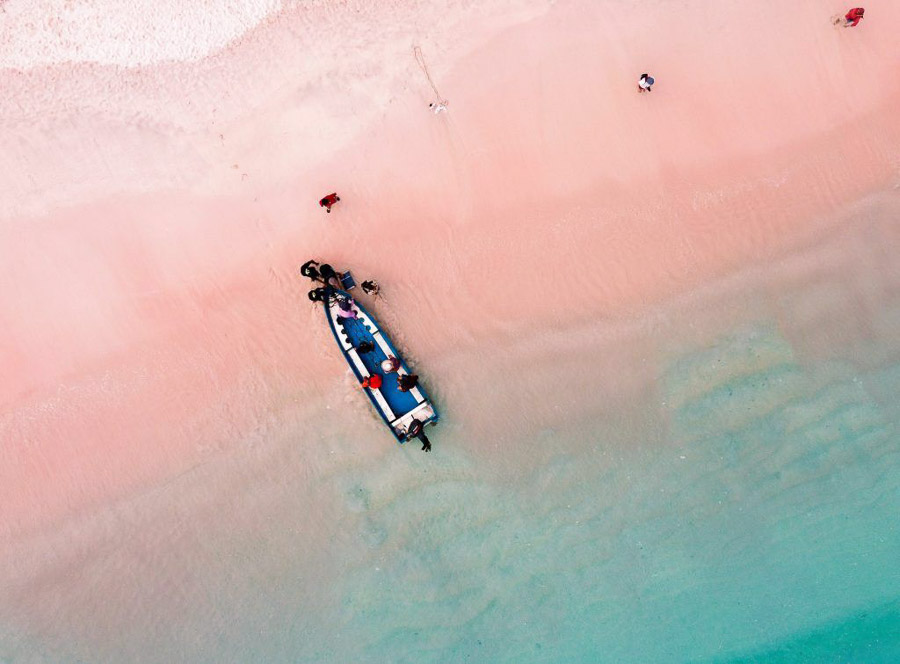 Vista aérea de una playa de arena rosada y aguas turquesas en Indonesia, uno de los paisajes más singulares de sus islas
