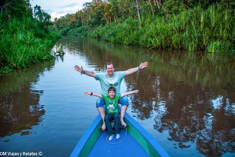 JC y nuestro hijo navegando por un río de Borneo, una experiencia de naturaleza en una de las mejores islas de Indonesia