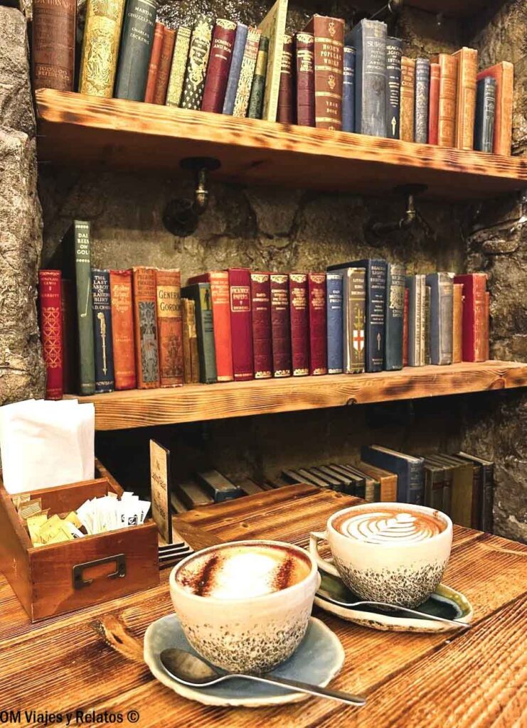 Dos cafés junto a una estantería de libros en Books N' Cup Café de Edimburgo