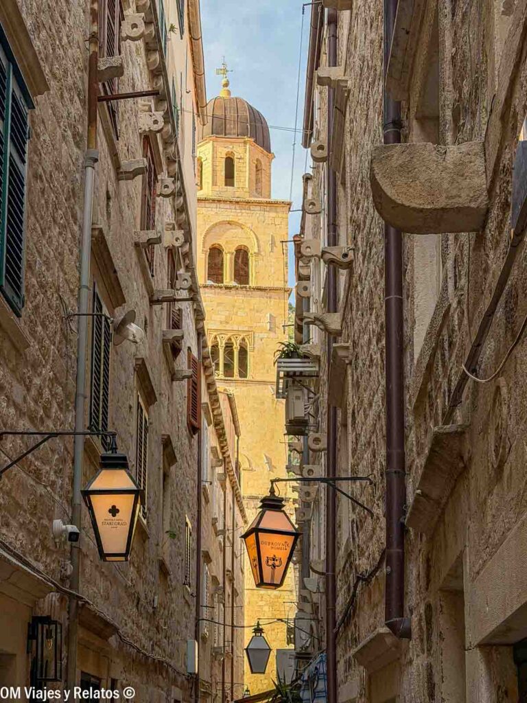 Calle del casco histórico de Dubrovnik con el campanario del Monasterio Franciscano al fondo