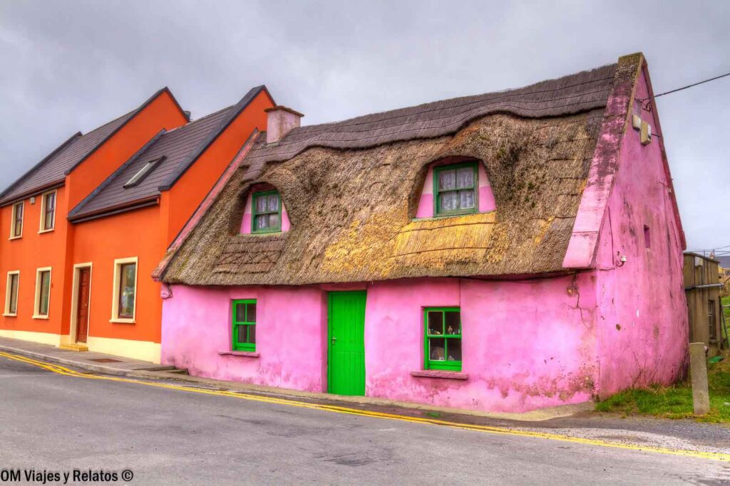Casa tradicional de color rosa con ventanas verdes y tejado de paja en Doolin, cerca de los Acantilados de Moher