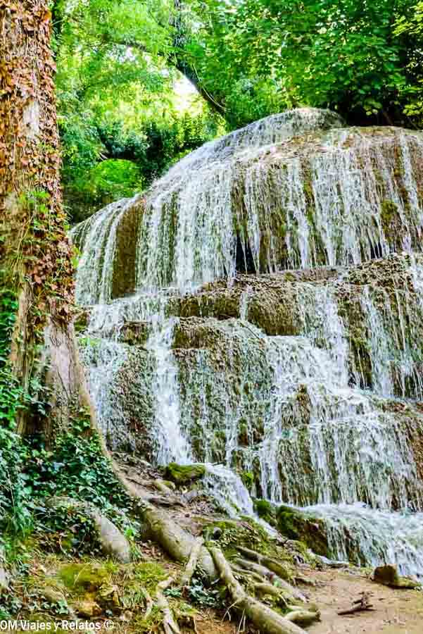 Cascada de varios niveles rodeada de árboles y vegetación, uno de los paisajes que ver en el Monasterio de Piedra