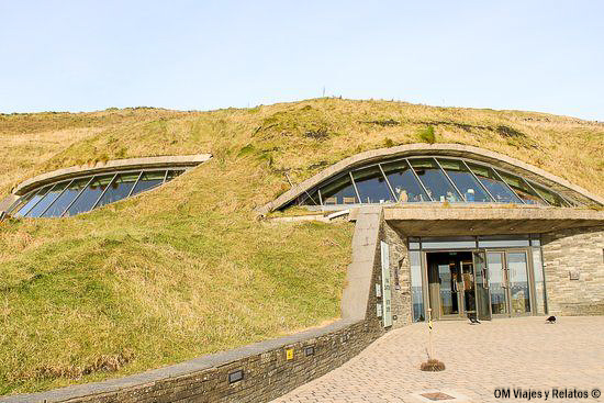 Entrada al Centro de Visitantes de los Acantilados de Moher, un edificio integrado en la ladera con una cubierta de césped y grandes ventanales
