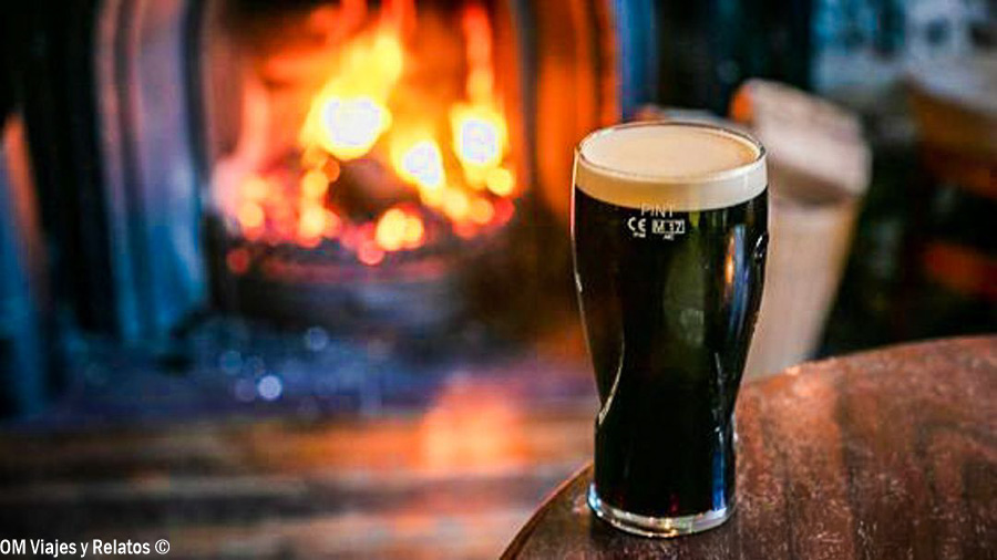 Pinta de Guinness junto a la chimenea de un pub durante nuestro viaje por Irlanda