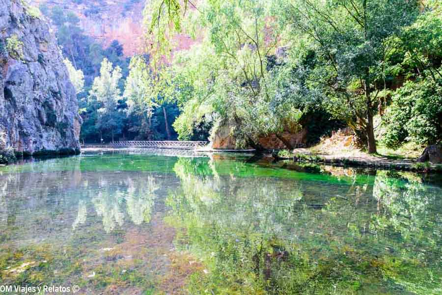 Lago de aguas cristalinas que reflejan los árboles y las paredes rocosas del Monasterio de Piedra, en Zaragoza