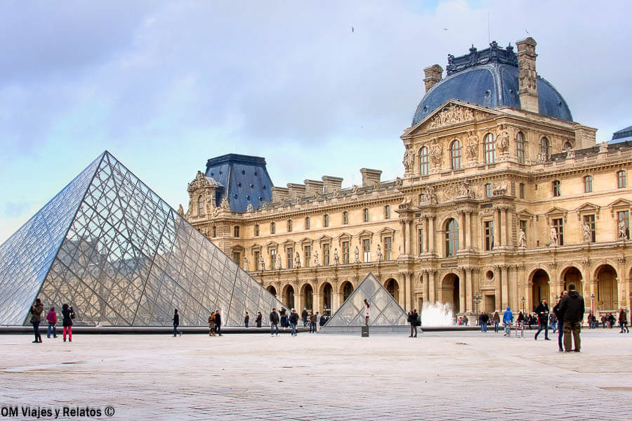 Pirámide de cristal y fachada histórica del Museo del Louvre, uno de los monumentos imprescindibles de París
