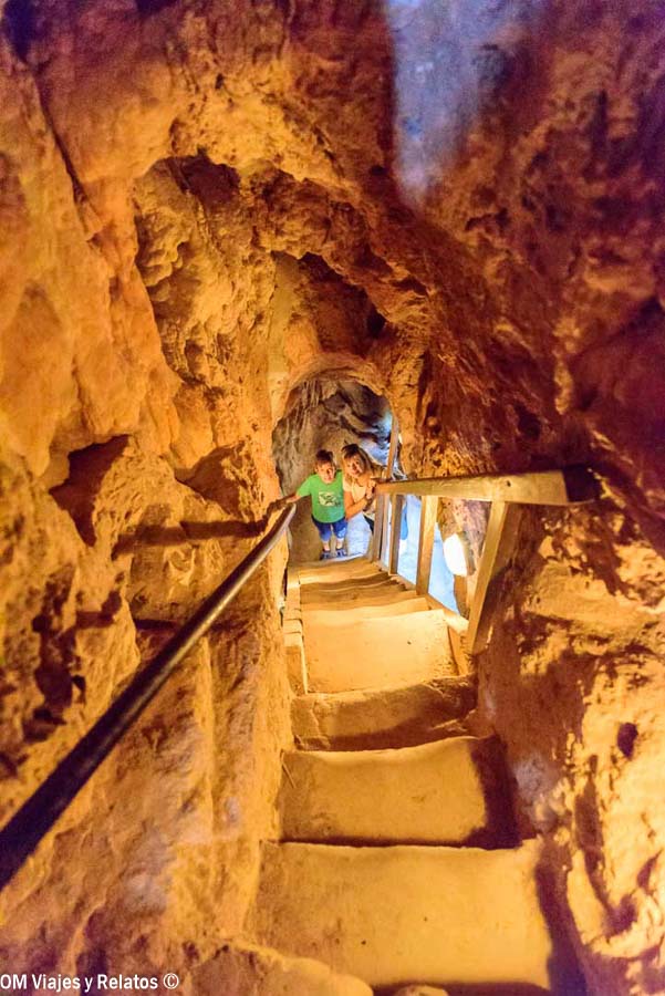 Foto de mi hijo y mía subiendo las escaleras de una gruta del Monasterio de Piedra, entre paredes rocosas iluminadas