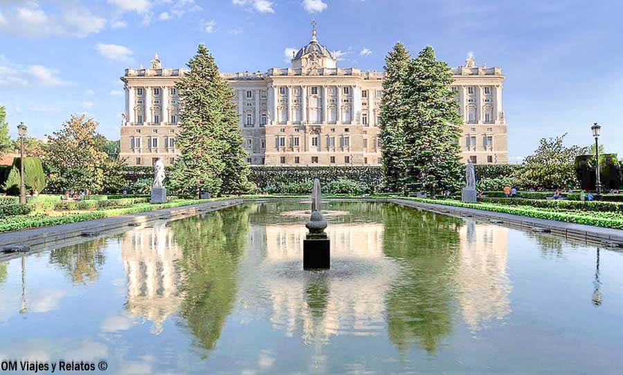 Vista del Palacio Real de Madrid desde los Jardines de Sabatini, con su estanque, fuentes y árboles reflejados en el agua