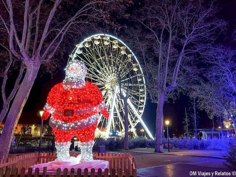 Papá Noel iluminado frente a la noria de Carcassonne en Navidad