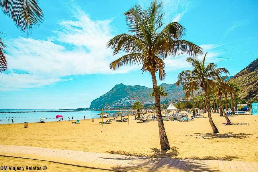 Playa de Las Teresitas en Tenerife, con arena dorada, palmeras y montañas junto al océano Atlántico