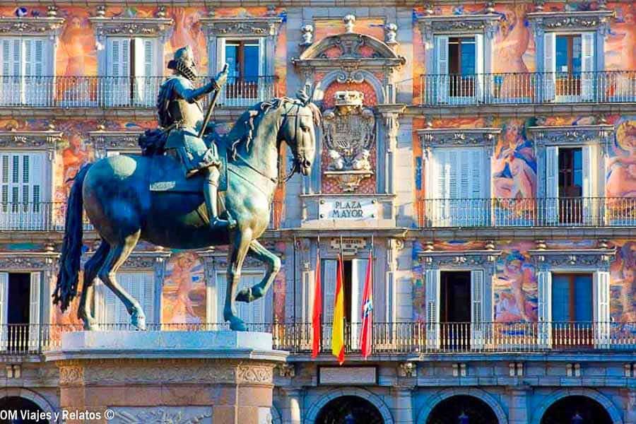 Estatua ecuestre de Felipe III frente a la Casa de la Panadería, con sus fachadas decoradas, en la Plaza Mayor de Madrid