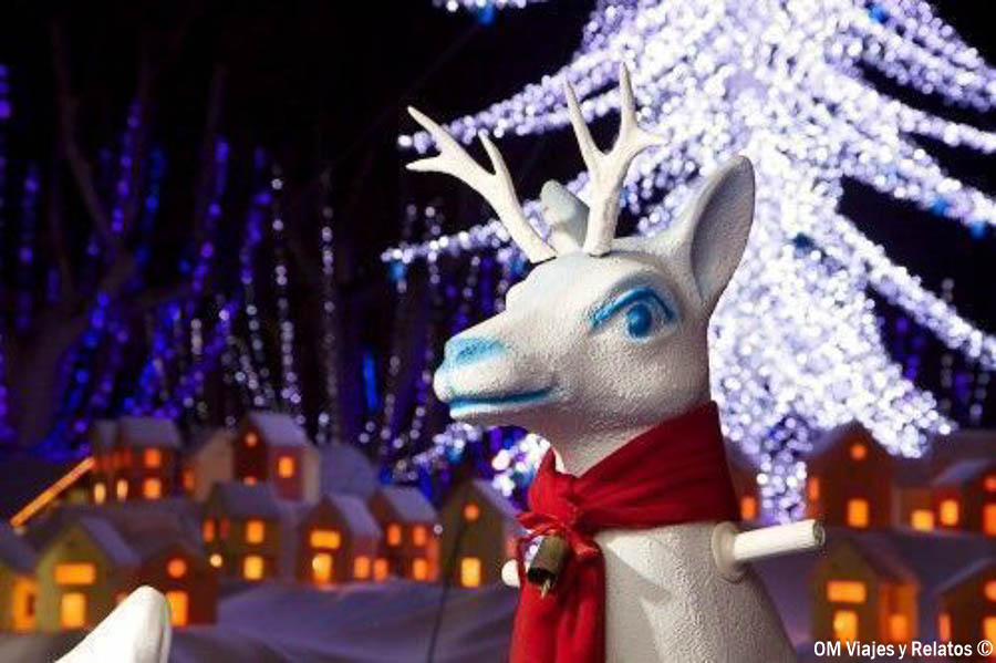 Reno decorativo junto a un árbol iluminado en Carcassonne en Navidad