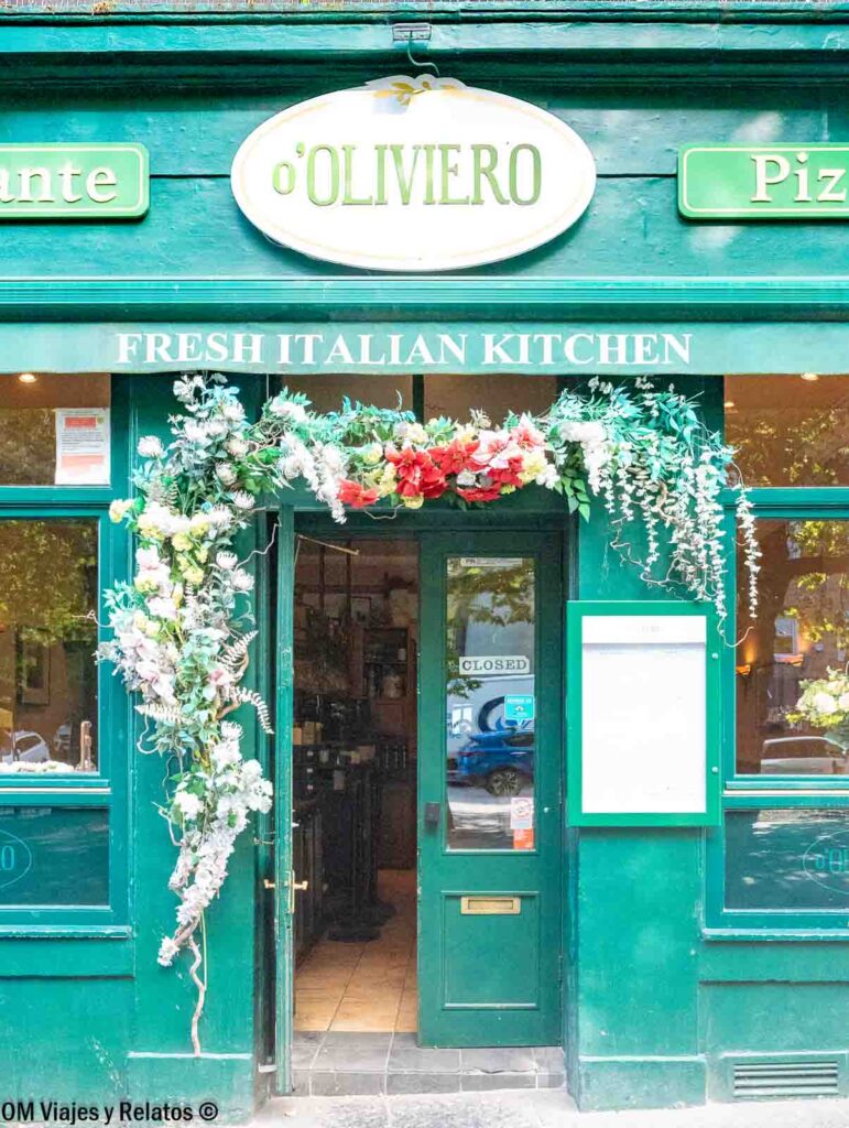 Fachada del restaurante O’Oliveiro en Edimburgo, con entrada verde decorada con flores