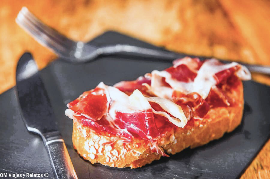 Tosta de jamón ibérico sobre pan crujiente, una de las tapas tradicionales que puedes degustar en Madrid